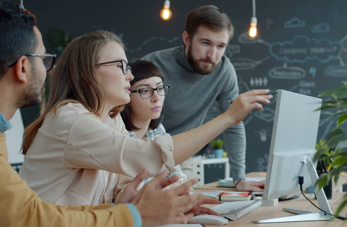 A professional services team reviewing work together on a computer